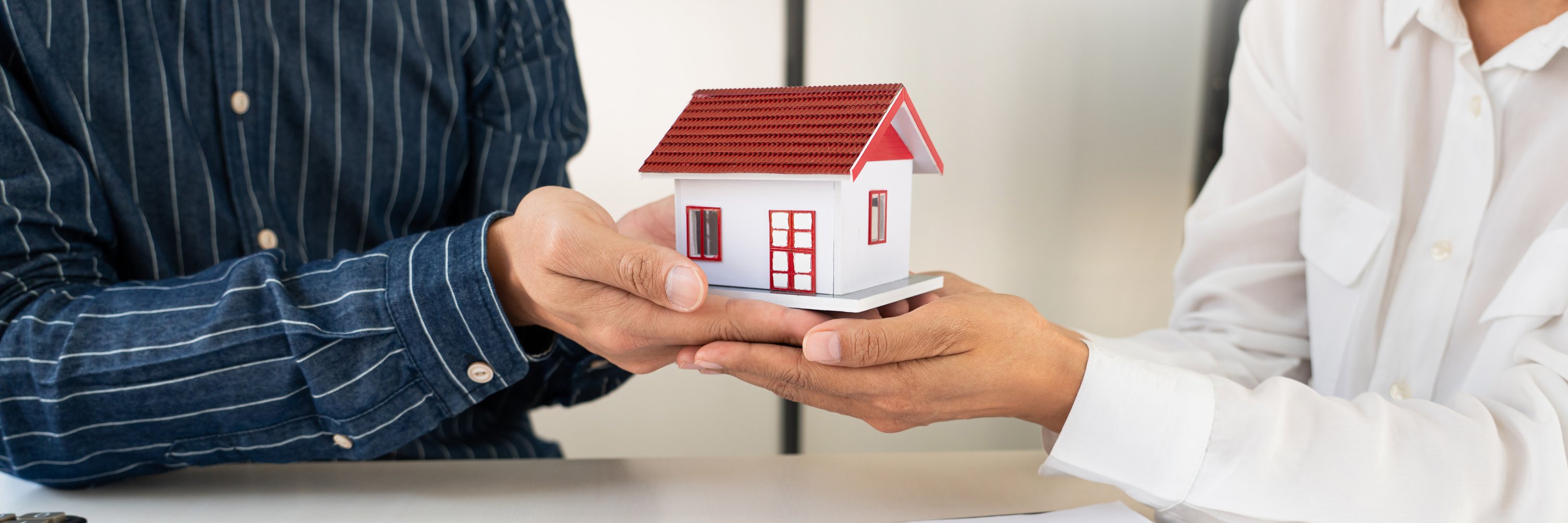 Couple Holding a Toy House Model