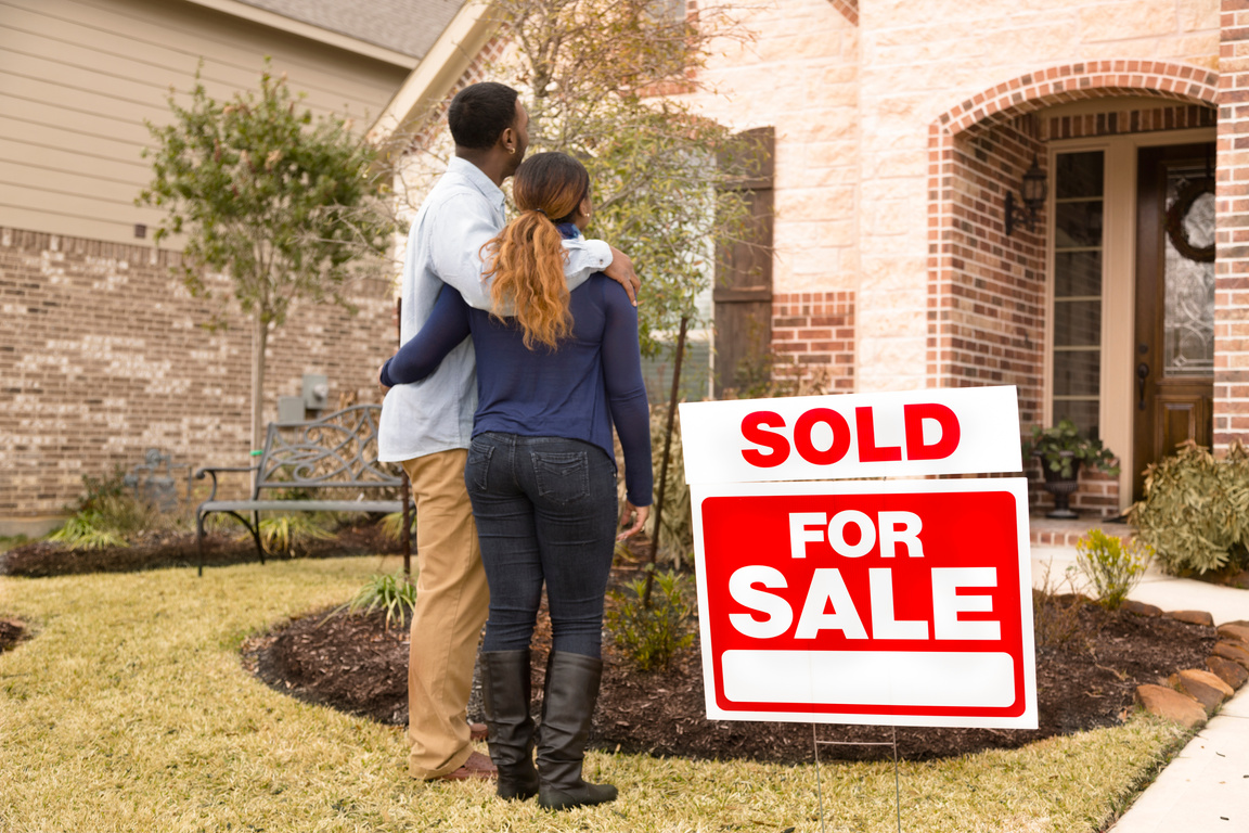 Real Estate: African descent couple admires new home. Happy homeowners!